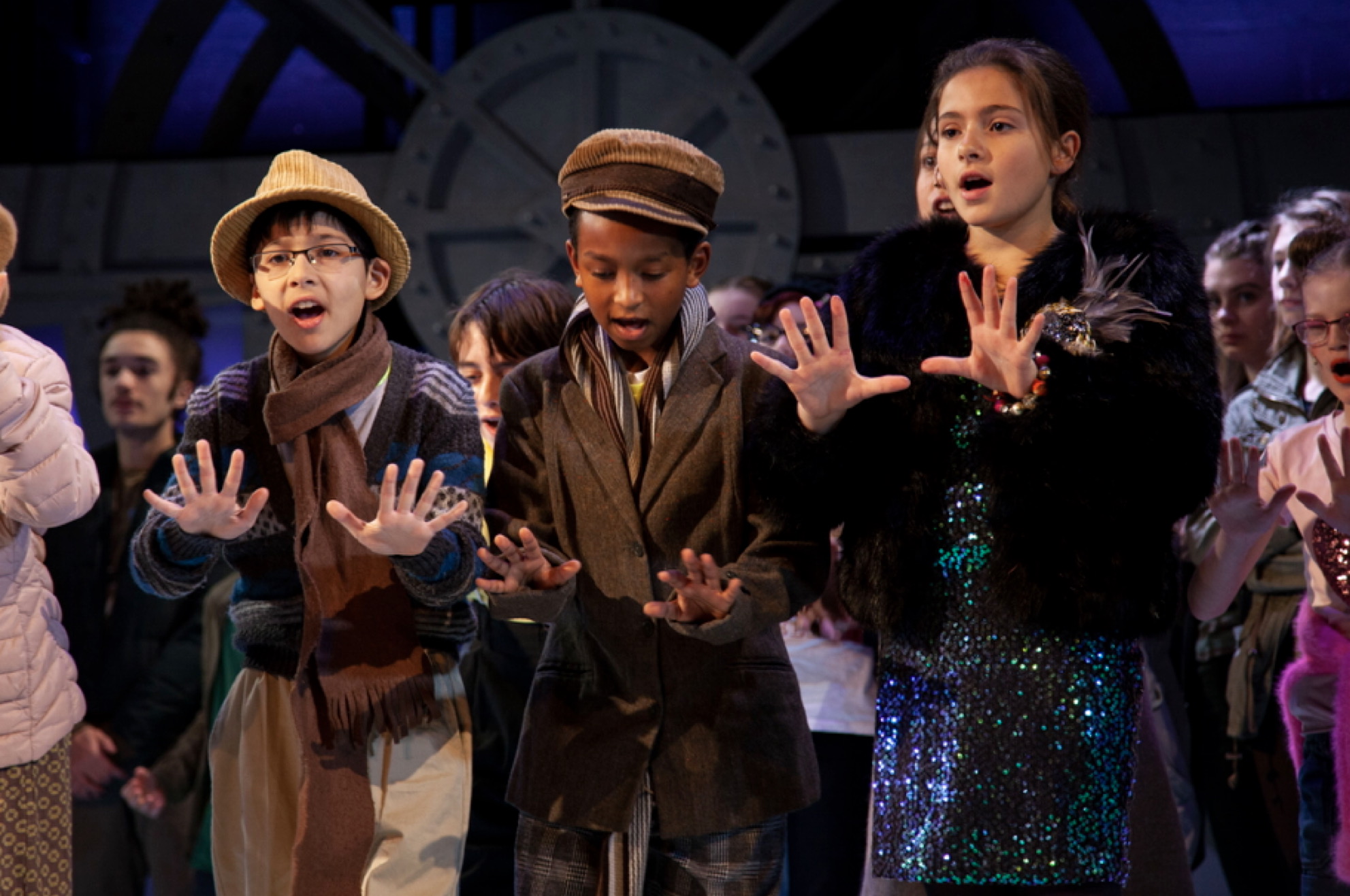Three young London Youth Opera performers singing together on stage.