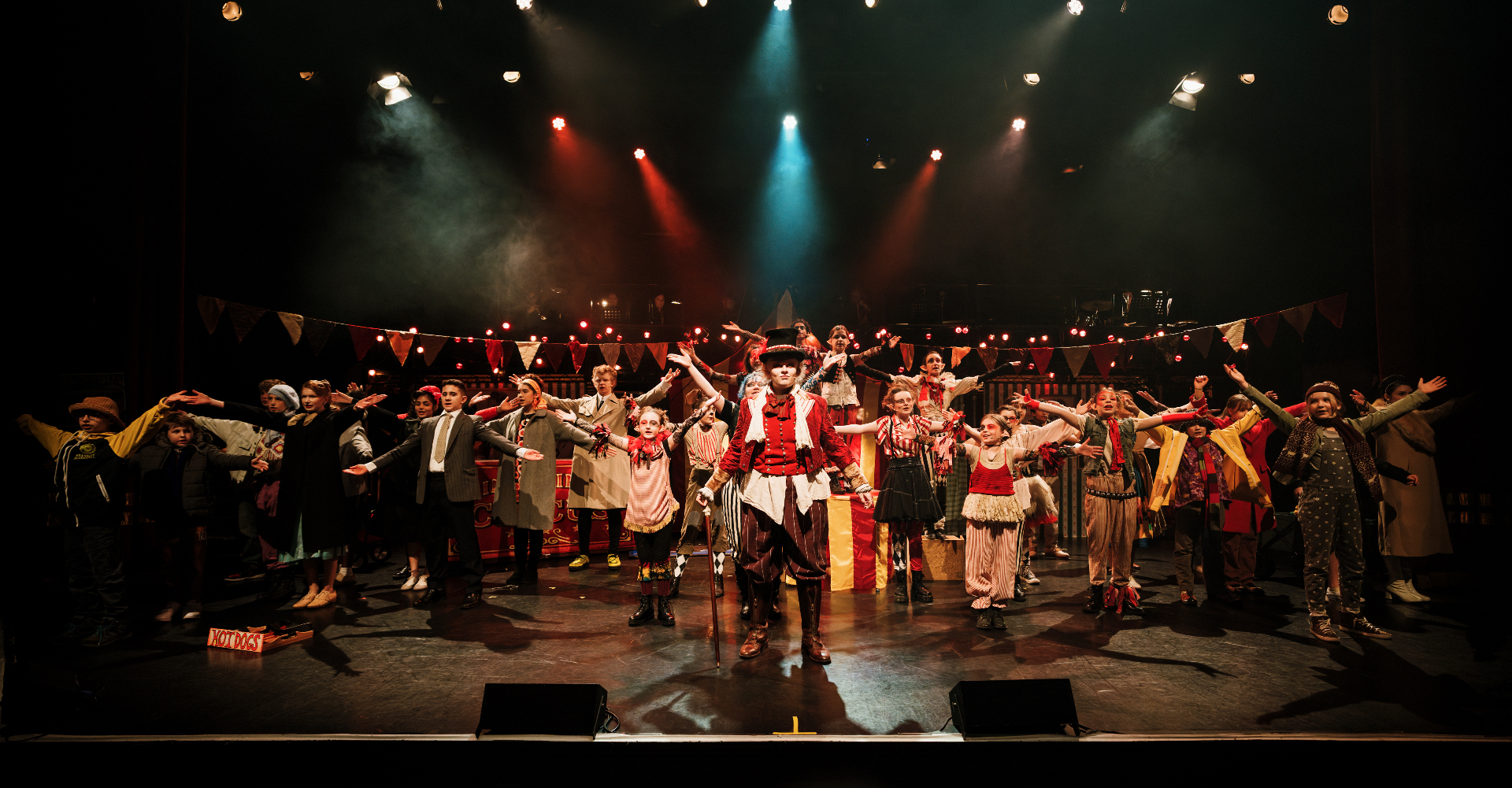 The full London Youth Opera company spread across the stage with the Ringmaster at the centre.
