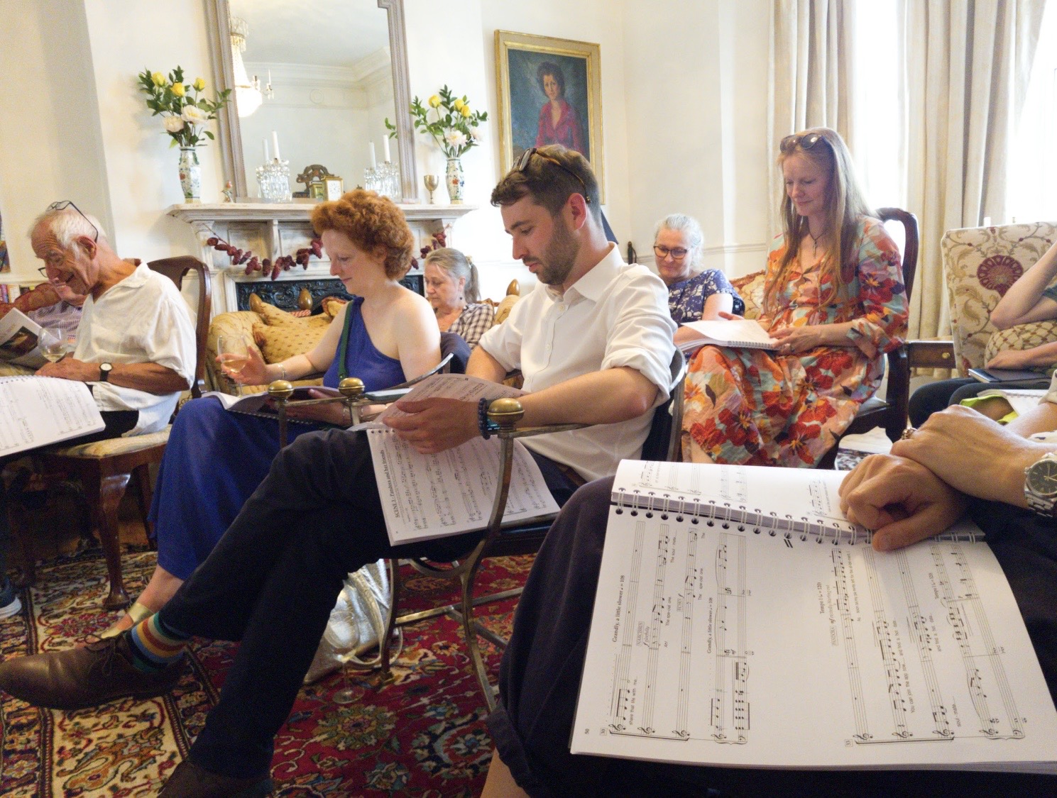 Writers, trustees and creative team gathered in a sitting room following the score during a sing-through.